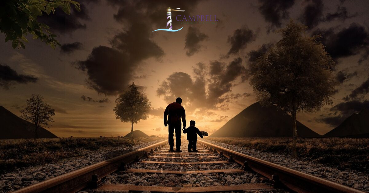 An adult and child walking along a railway track. Campbell Leadership Solutions